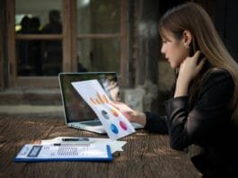 Social media marketer analyzing engagement metrics on a laptop to boost brand visibility.