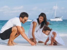 Family having a budget-friendly vacation at the beach, enjoying a picnic together.